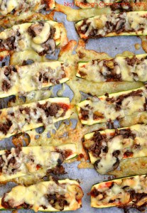 Baked Cheesy Beef and Mushroom Zucchini Boats on a baking sheet with lots of crunchy cheese crust forming around the zucchini