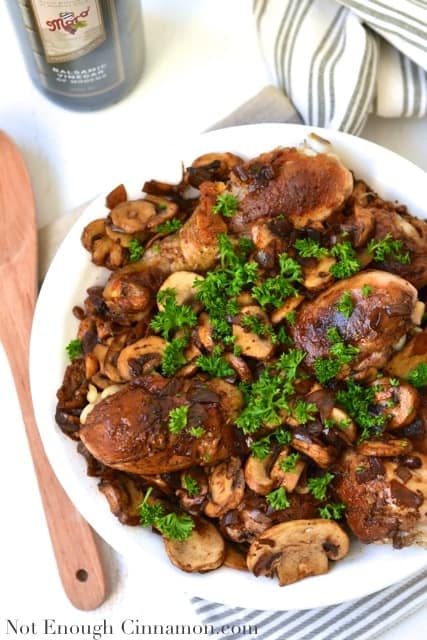 Chicken Drumsticks in a Mushroom and Shallot Balsamic Sauce served on a white plate