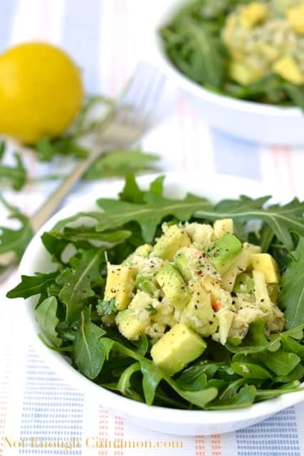 Crab and Avocado Salad served on a bed of arugula in a white bowl