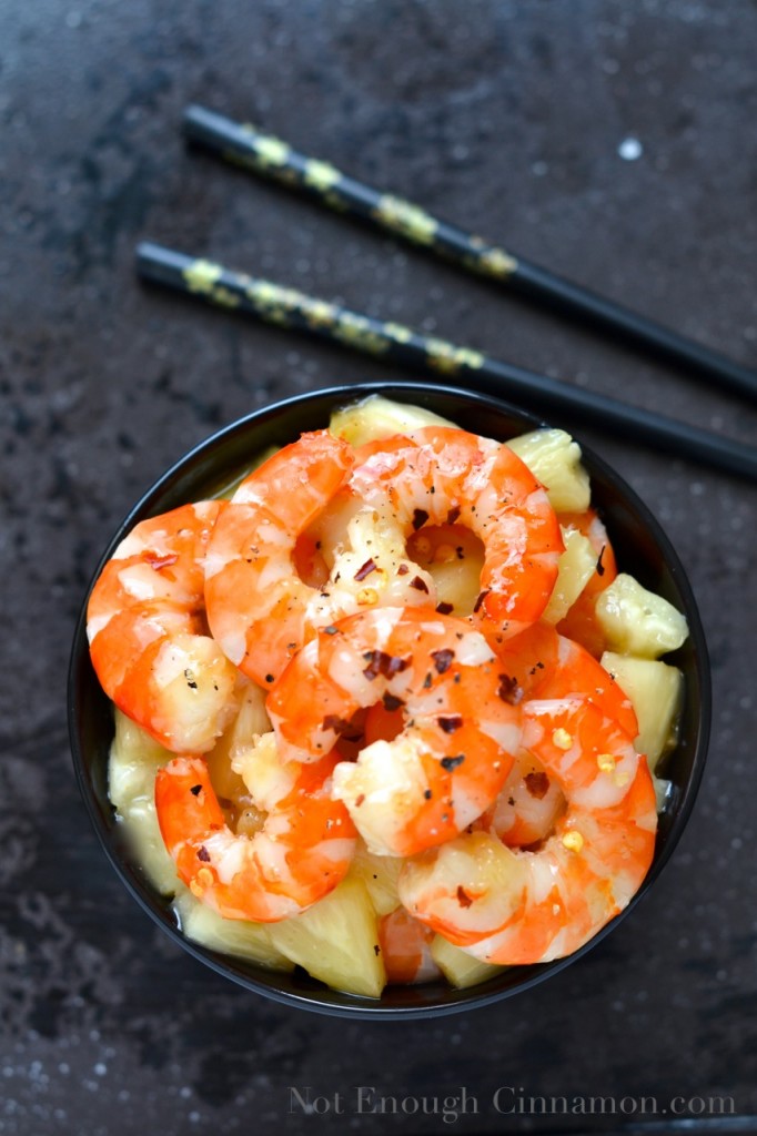 overhead shot of Honey Pineapple Shrimp in a black bowl with chopsticks on the side