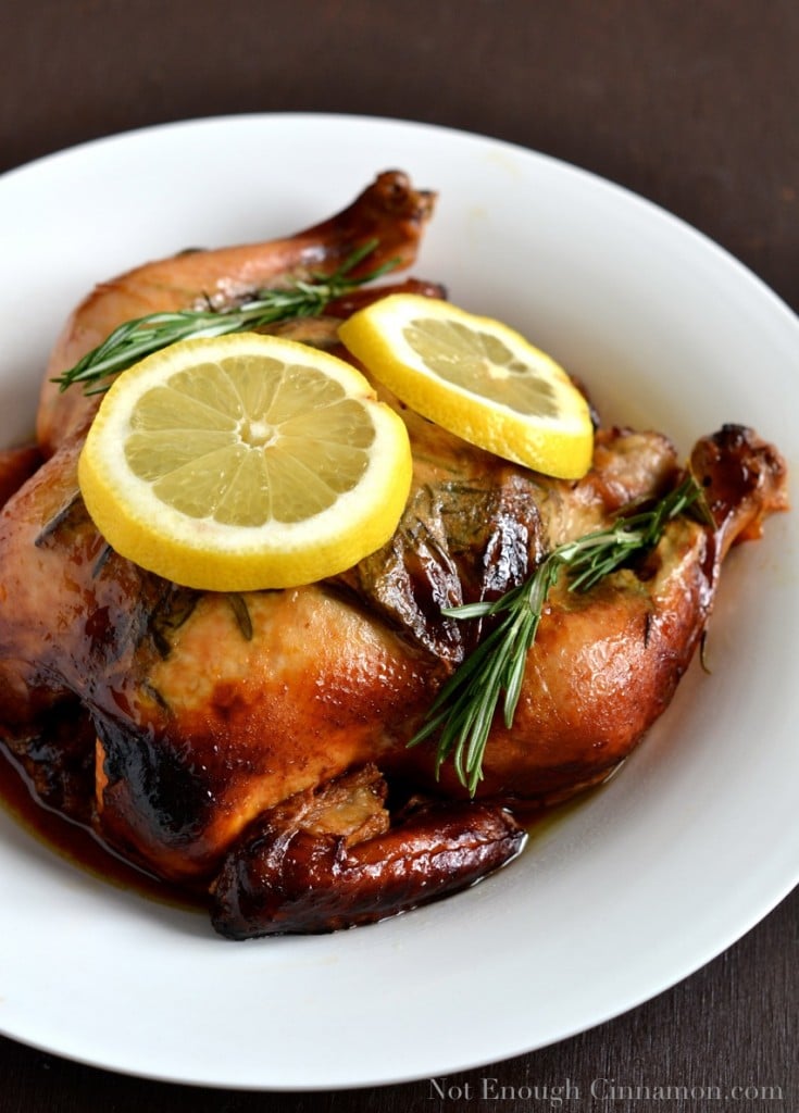 Slow Cooker Lemon and Rosemary Whole Chicken in a white bowl decorated with lemon slices and fresh rosemary