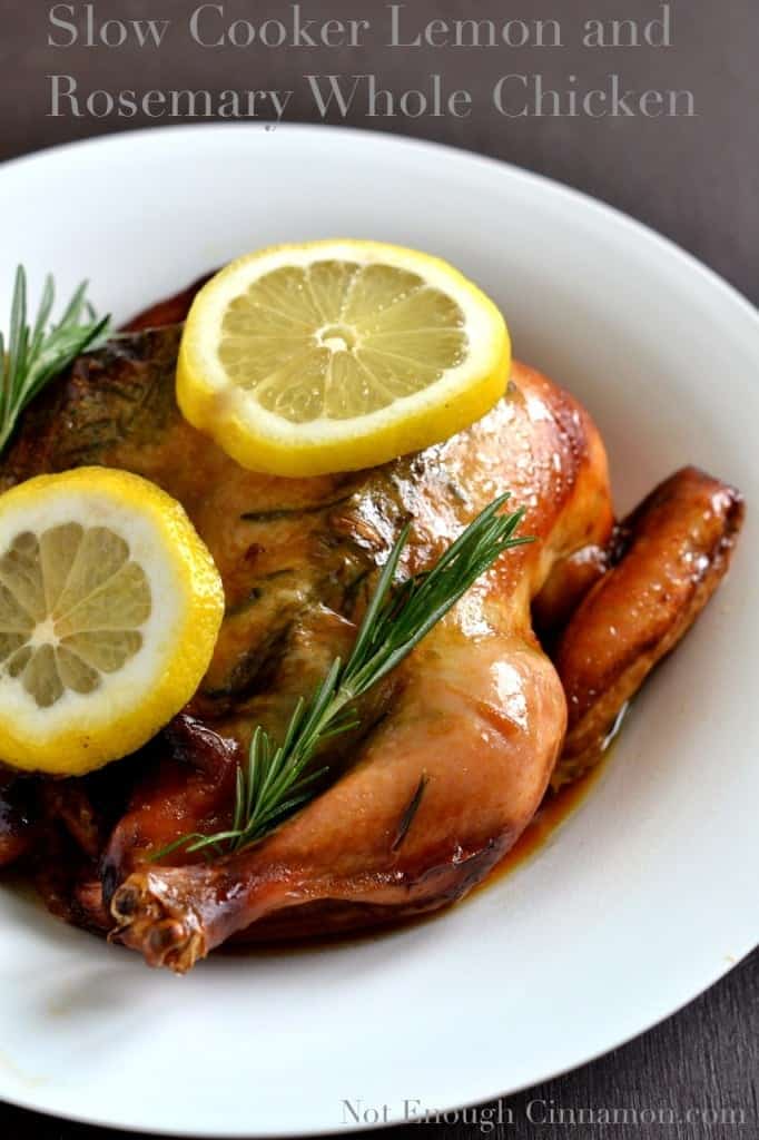 crispy Slow Cooker Whole Chicken topped with lemon slices and rosemary sprigs served in a big white dish