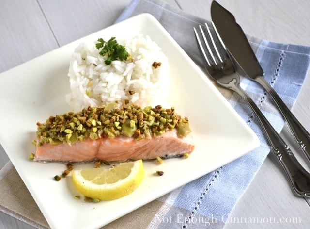 Salmon with Green Olive and Pistachio Topping served on a white plate