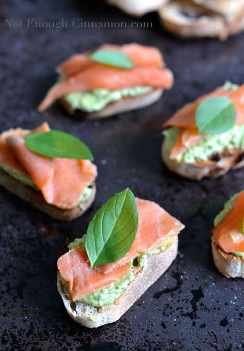 Smoked Trout and Basil Pesto Cream Cheese Crostini served on a black tabletop