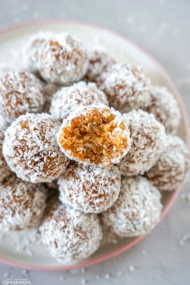 A pile of paleo energy bites in a plate with one bite bitten at the top