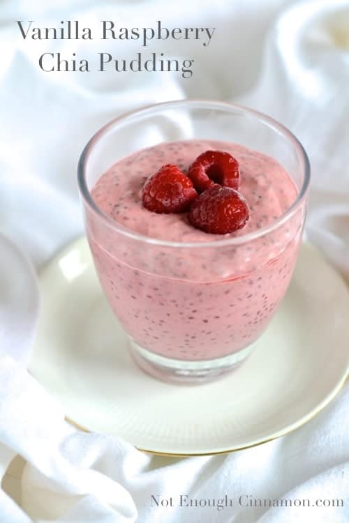 Vanilla Raspberry Chia Pudding served in a dessert glass with three fresh raspberries on top