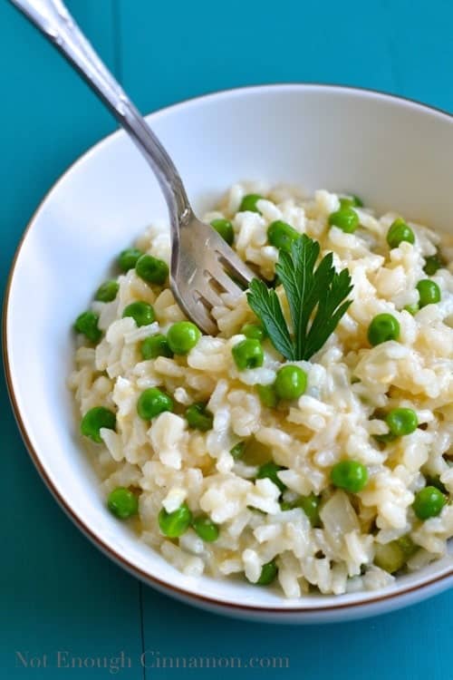 a fork sticking out of a bowl with creamy risotto primavera