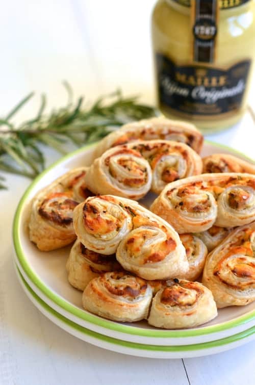 a plate of savory Goat Cheese, Mustard and Rosemary Palmiers with a jar of mustard in the background