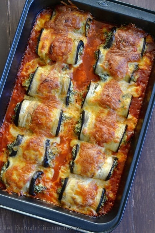 Skinny Eggplant Rollatini with a golden brown cheese crust and tomato sauce in a metal baking dish