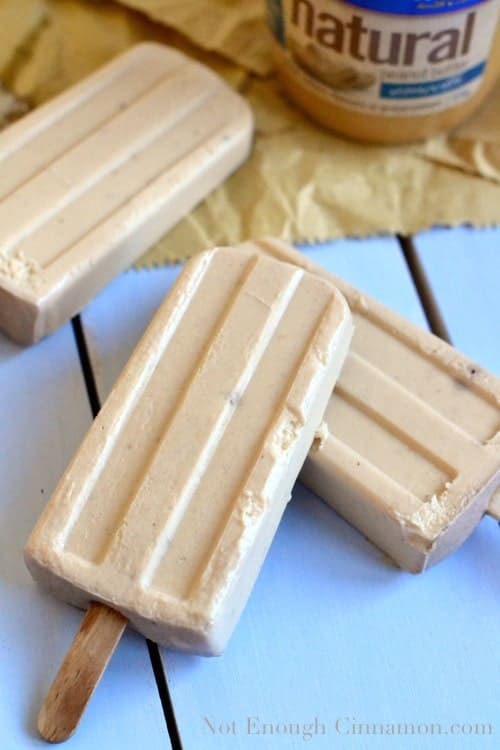 Banana Peanut Butter Yogurt Popsicles stacked on top of each other on a rustic tabletop 