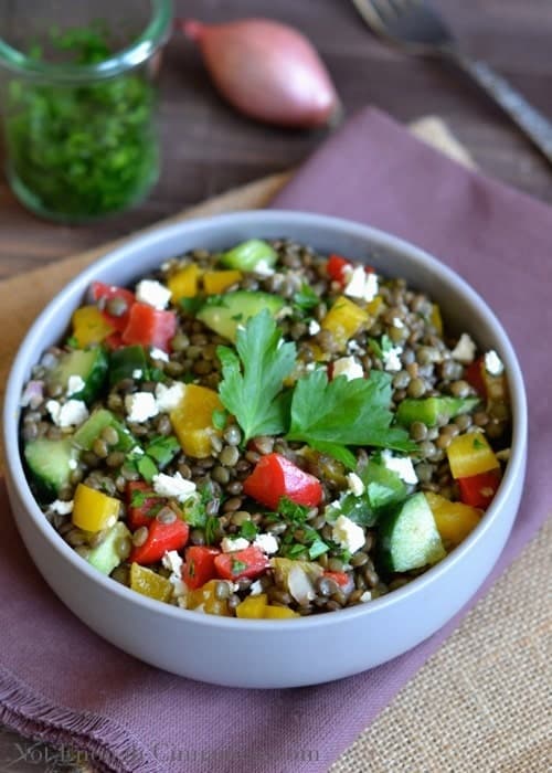 Easy Lentil Bell Pepper Salad with crumbled feta cheese and chopped parsley on top served in a grey salad bowl