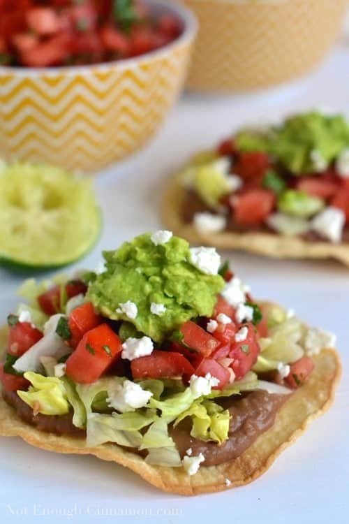 side view of Vegetarian Baked Tostadas topped with refried beans, homemade pico de gallo and creamy mashed avocado 