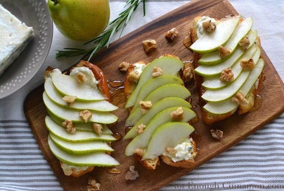 Pear and Gorgonzola Brioche Toast drizzled with honey and sprinkled with chopped walnuts served on a wooden board