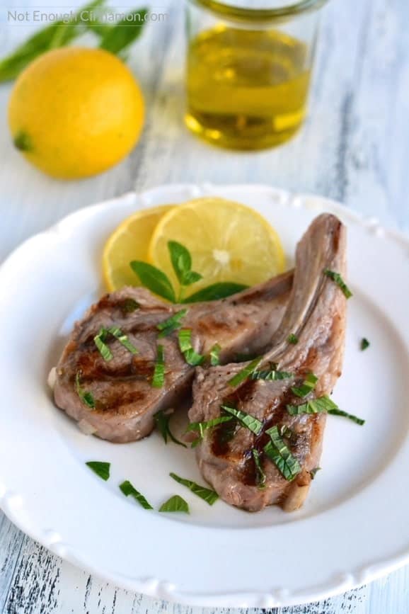 Lamb chops marinated in a delicious mix of lemon, olive oil and fresh mint. Perfect for a summer BBQ! Paleo and Gluten Free - Find the recipe on NotEnoughCinnamon.com