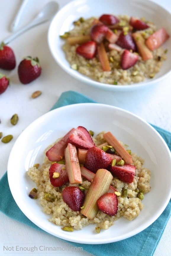 Quinoa Porridge with Roasted Rhubarb and Strawberries served in two white bowls sprinkled with chopped pistachios