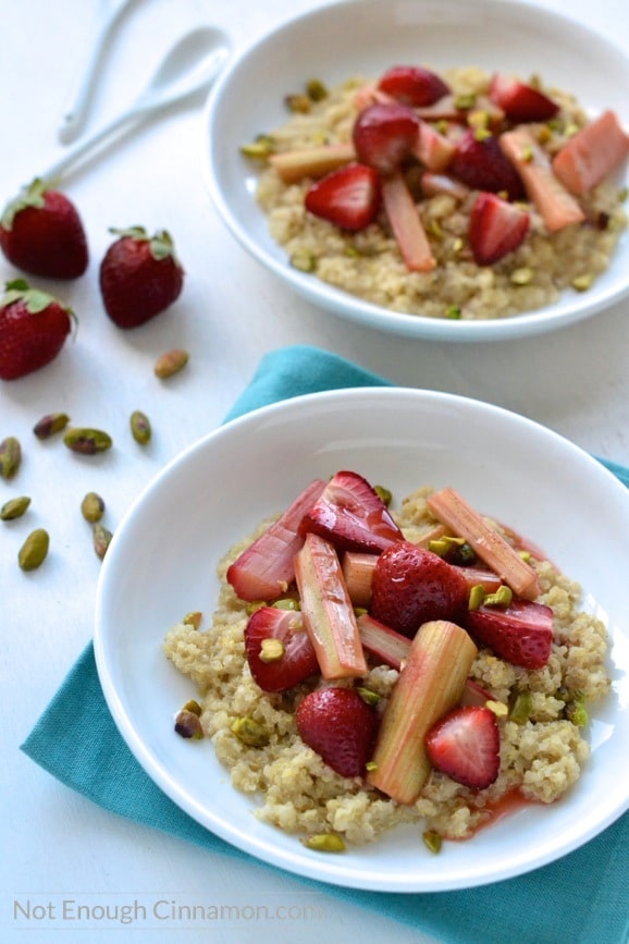 close-up of Quinoa Porridge with Roasted Rhubarb and Strawberries served in two bowls with some strawberries and pistachios on the side 