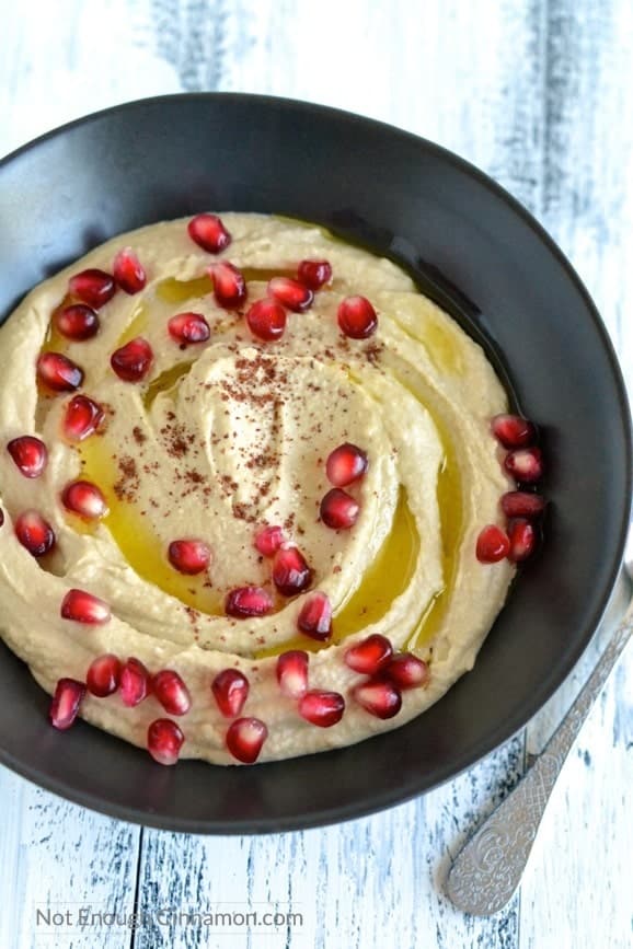 overhead shot of homemade easy hummus drizzled with olive oil and sprinkled with pomegranate seeds and sumac