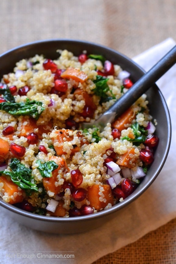 close-up of a bowl of vegan warm quinoa sweet potato kale salad tossed with an easy orange olive oil dressing