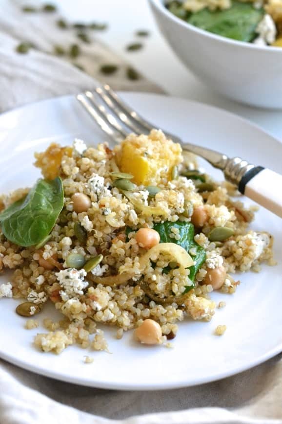 Bondi harvest quinoa salad with roasted squash, chickpeas, goat cheese and spinach on a white plate