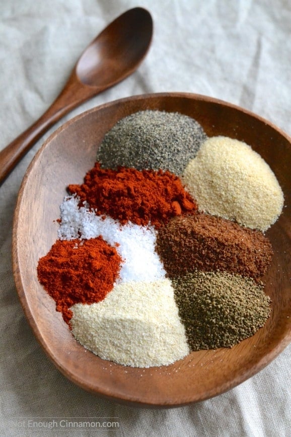 ingredients for a Homemade BBQ Spice Rub assembled on a wooden bowl with a small wooden spoon on the side