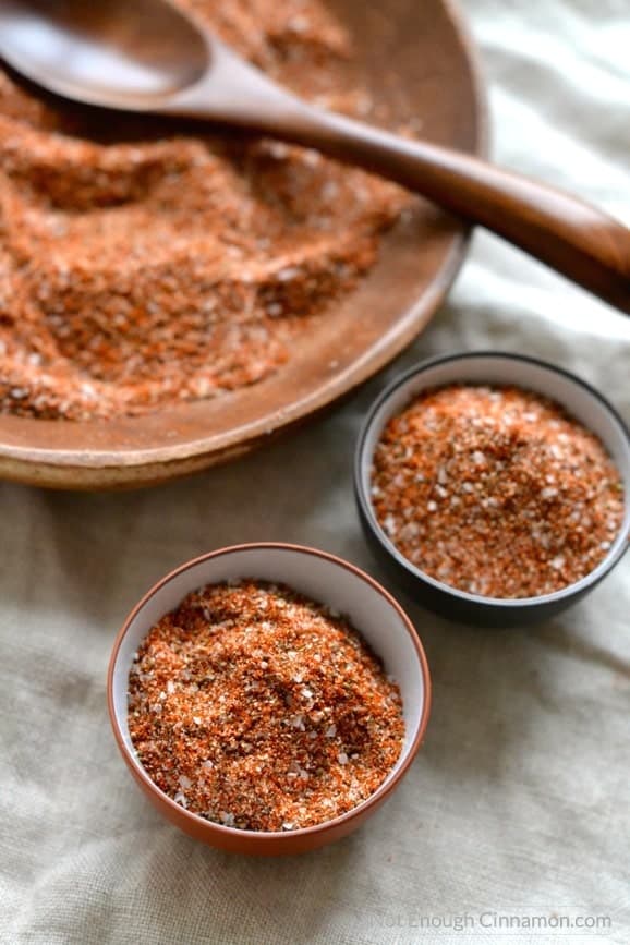 Homemade BBQ Spice Rub portioned out into little dishes with a big wooden bowl of dry rub in the background