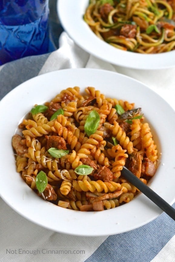 two bowls of Italian Sausage Pasta - one with Fusilli and one with Zucchini Noodles
