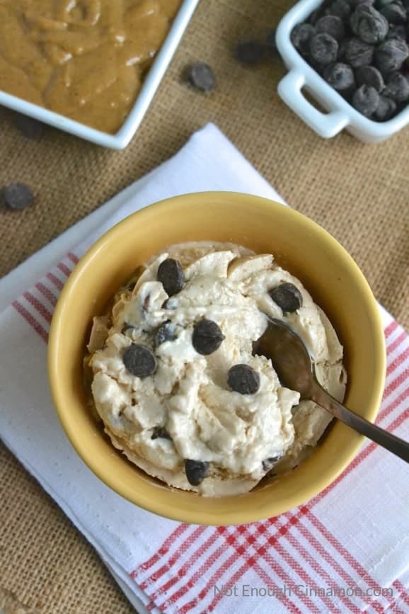 overhead shot of a bowl of Peanut Butter Cups Healthy Frozen Yogurt with some chocolate chips and peanut butter in the background