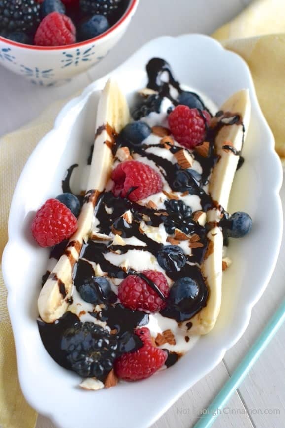close-up of healthy banana split with Greek Yogurt, fresh berries and sugar-free homemade chocolate sauce 