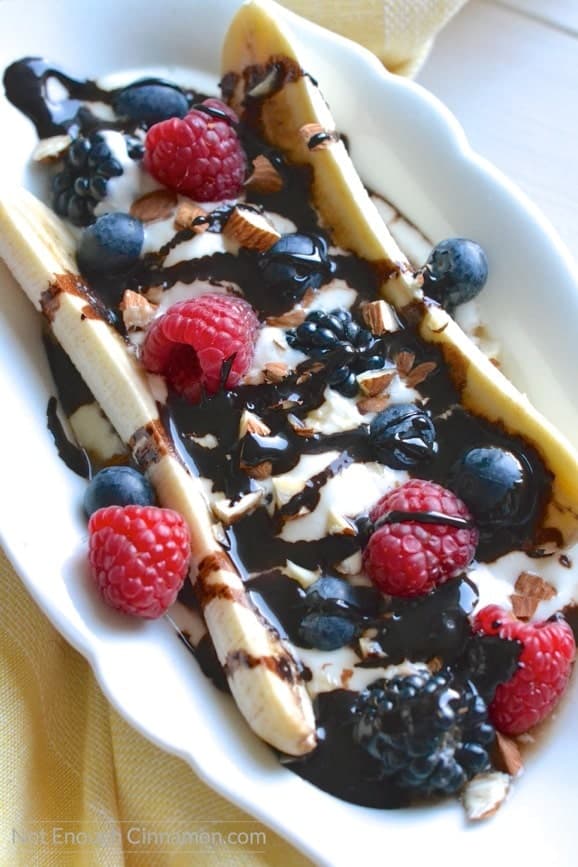 overhead shot of healthy banana split filled with berries and drizzled with clean eating sugar-free chocolate sauce