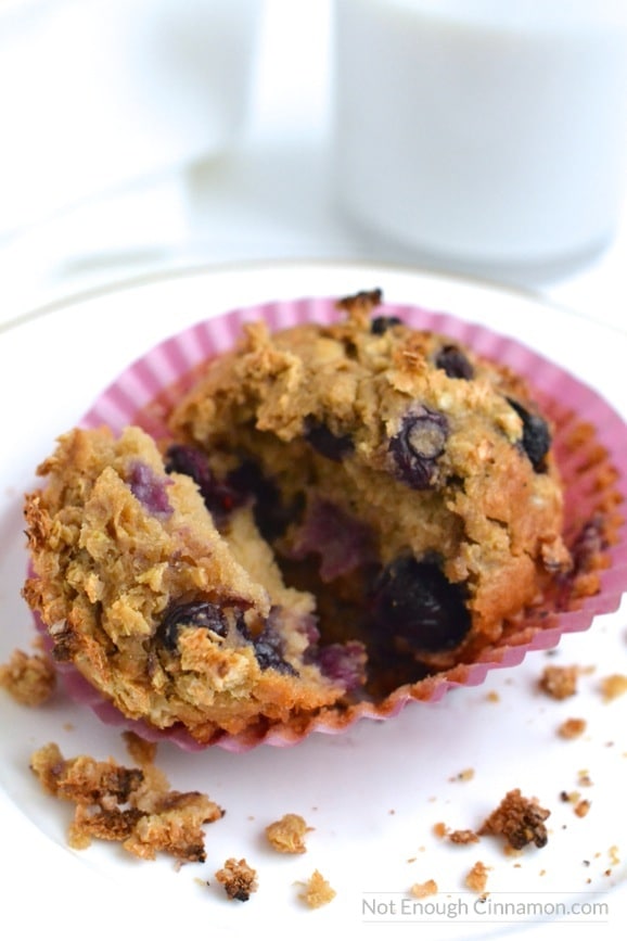 a Clean Eating Breakfast Muffin with apples, quinoa and blueberries in a muffin liner, broken into two pieces