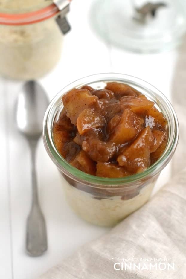 close-up of Clean Eating Apple Pie Overnight Oats in a small mason jar with a spoon on the side