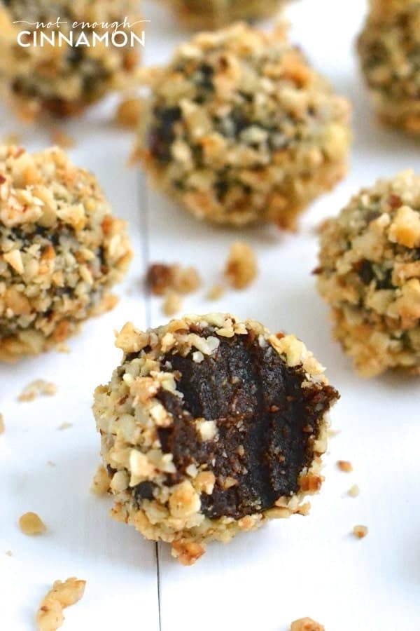 close up of Clean Eating Cacao & Hazelnut Energy Bites on a white wooden tabletop