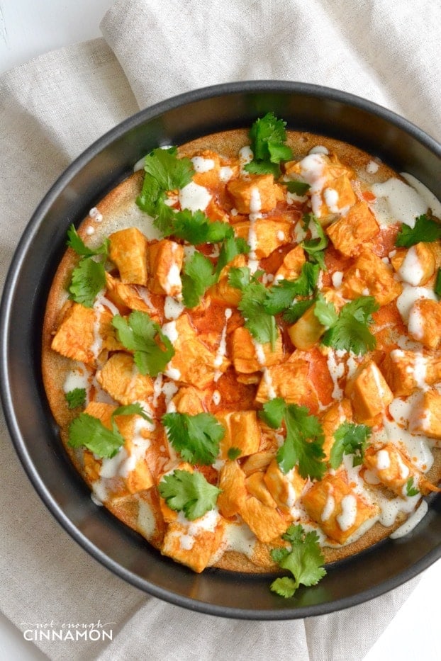 overhead shot of Skinny Buffalo Chicken Pizza with quinoa pizza crust topped with cilantro and skinny blue cheese dressing 