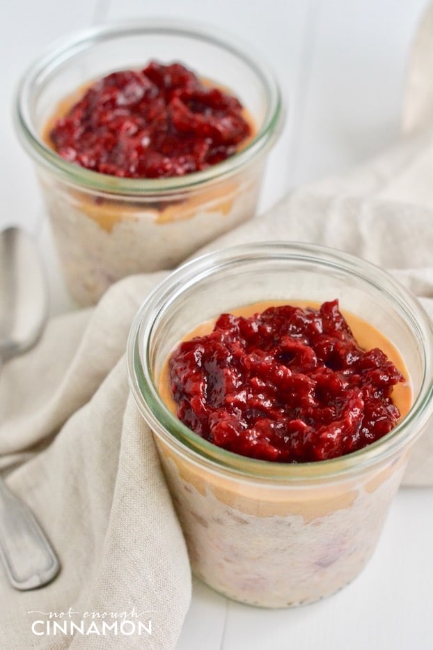 side view of two mason jars of peanut butter and jelly overnight oats with homemade refined sugar-free raspberry jam