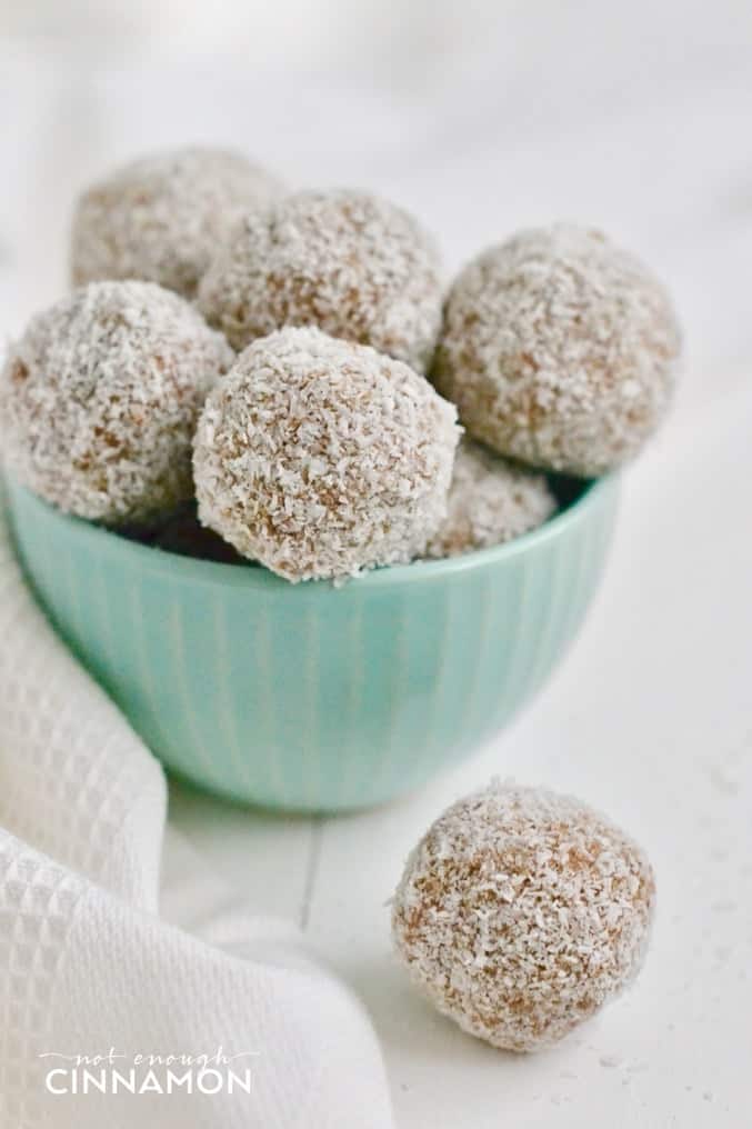 paleo banana bread energy bites rolled in shredded coconut in a mint bowl 