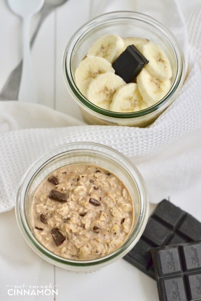 overhead shot of Peanut butter chocolate overnight oats in a mason jar with banana slices and dark chocolate on the side