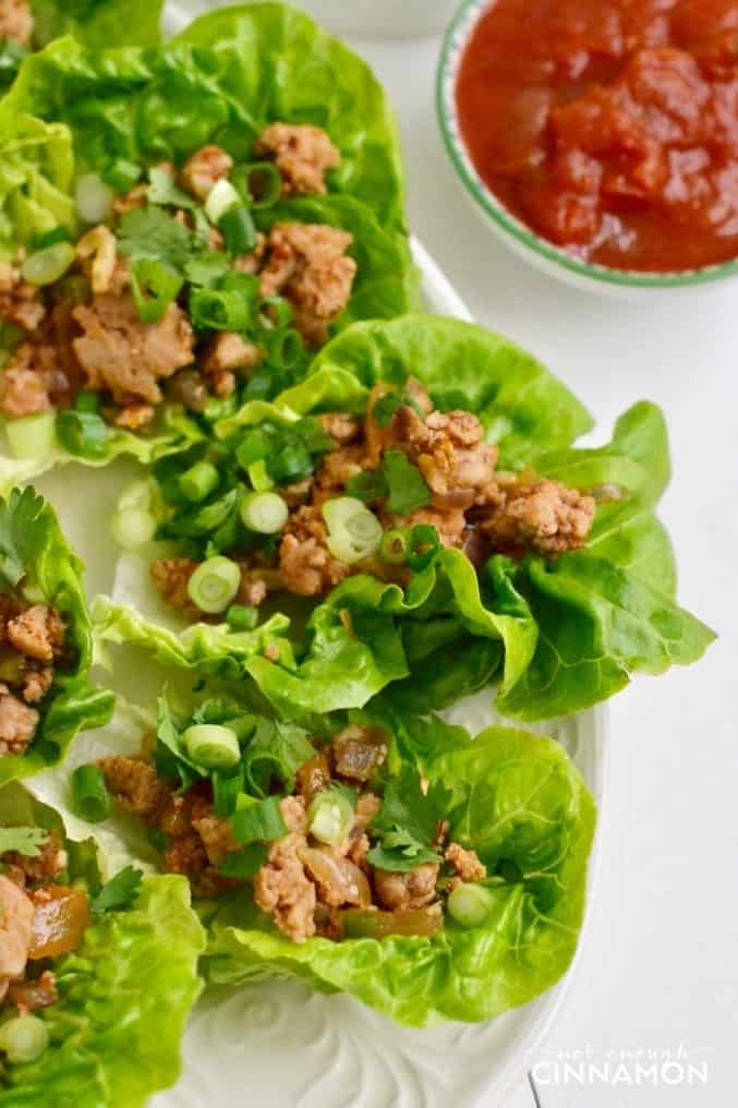 close-up of low-carb turkey lettuce wraps with chopped scallions and fresh cilantro on top of ground turkey filling
