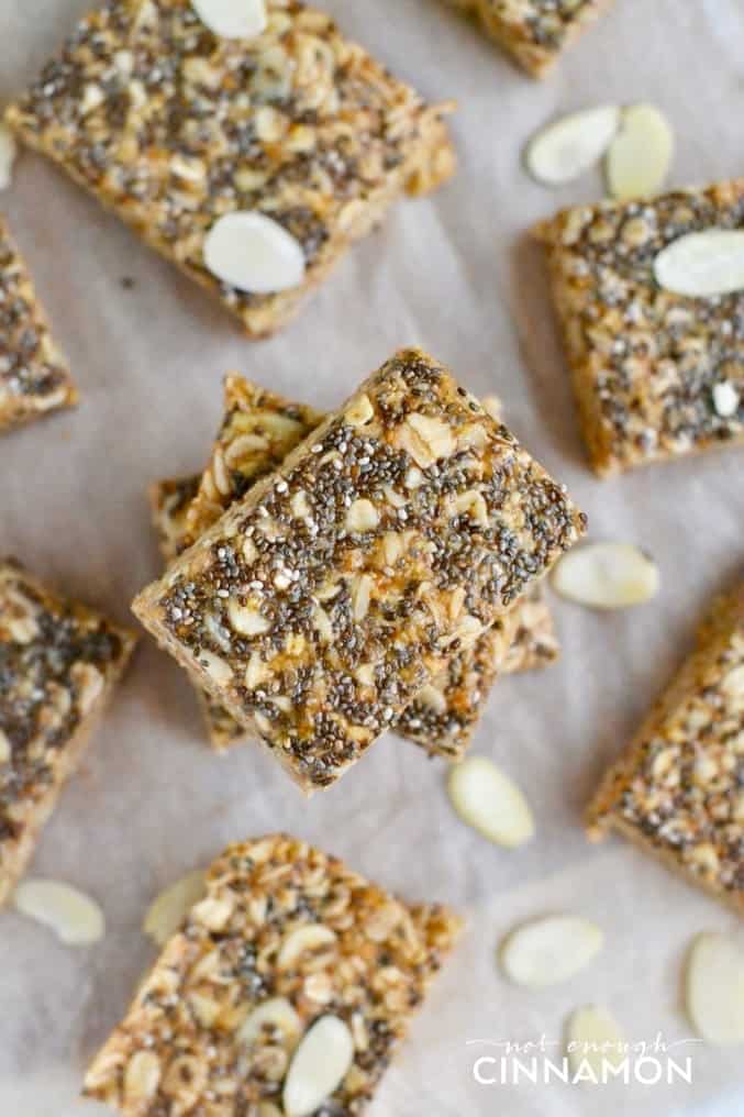 overhead shot of honey almond no-bake oatmeal bars with chia seeds on top arranged on a lined baking sheet