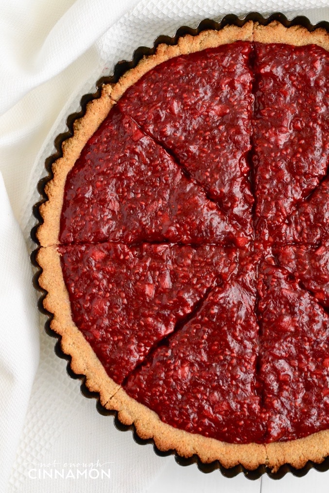 overhead shot of paleo raspberry tart with cinnamon-spiced coconut flour tart shell 