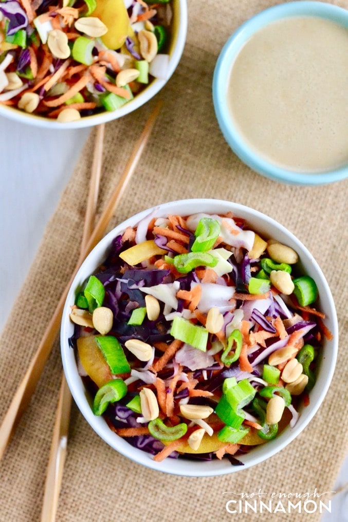 overhead shot of two bowls of Asian slaw with ginger peanut dressing on the side