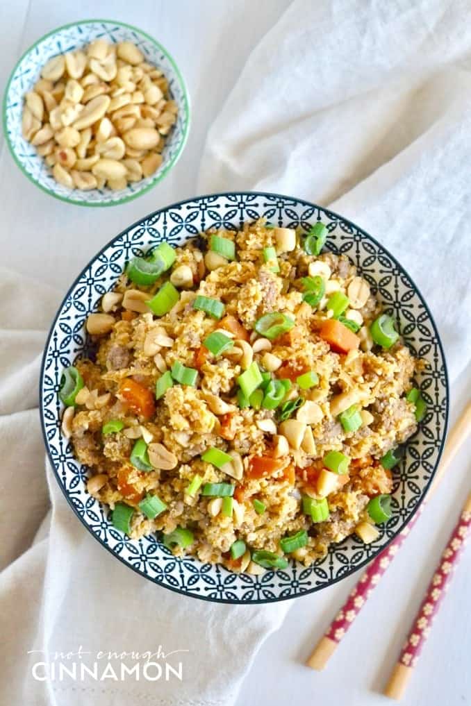 overhead shot of a bowl of healthy Asian cauliflower fried rice with some peanuts on the side