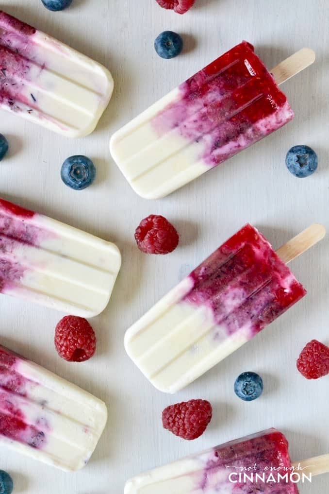 overhead shot of homemade healthy berry and Greek yogurt popsicles on a white table