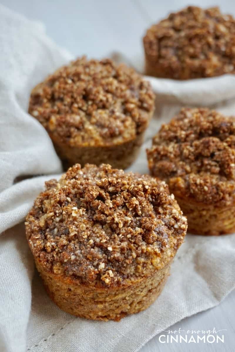 Gluten Free Apple Snickerdoodle Muffins on a white tablecloth