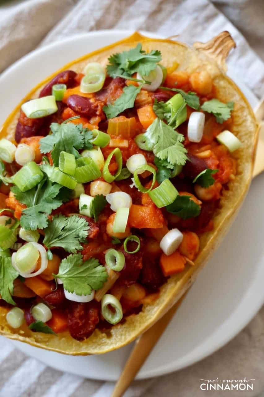 overhead shot a spaghetti squash boats filled with vegan chili and sprinkled with cilantro and scallions