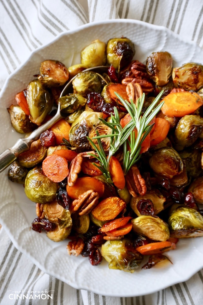 overhead shot of a plate of maple roasted vegetables with balsamic vinegar, rosemary and pecans