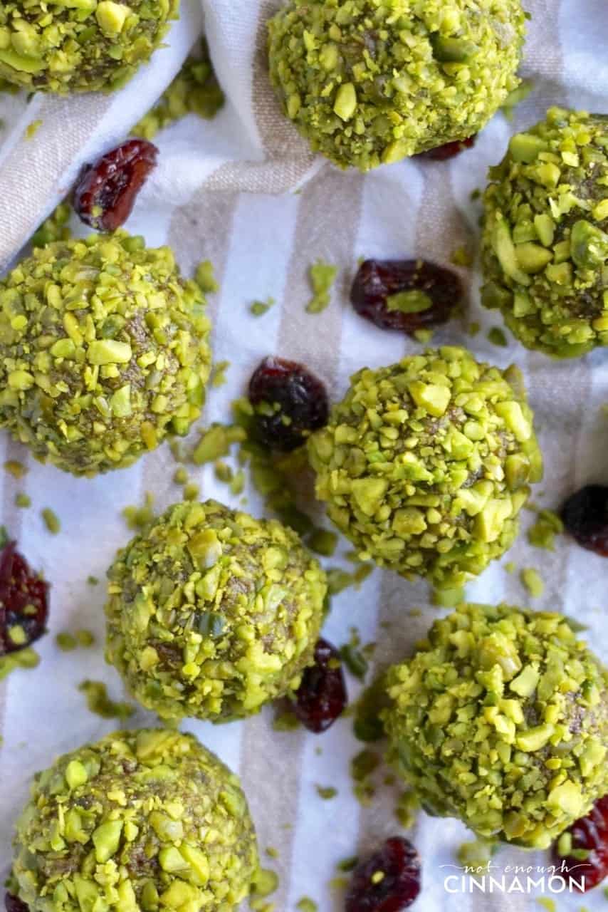 overhead shot of vegan paleo energy balls with cranberries and pistachios on a striped napkin