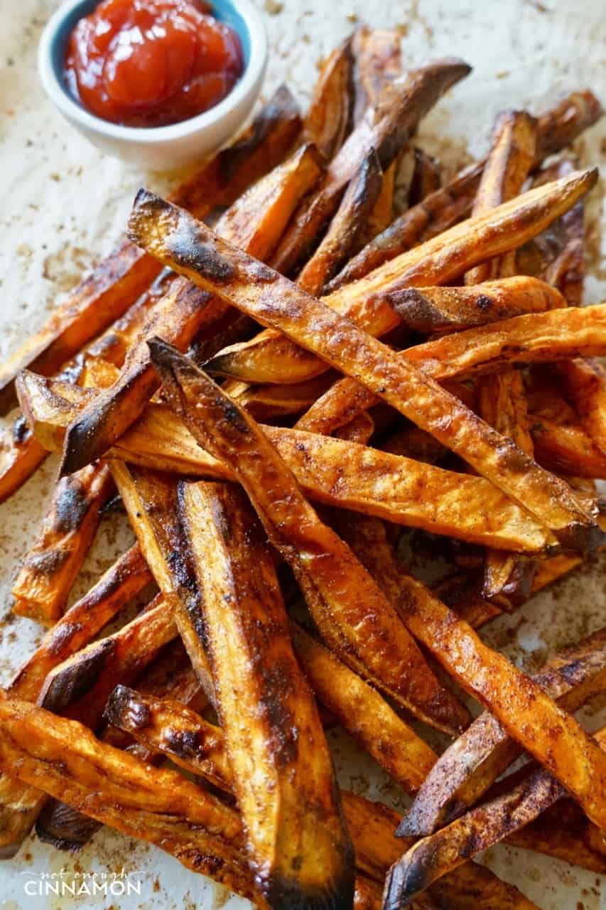 overhead shot of a pile of baked sweet potato fried spiced with cinnamon and coconut sugar