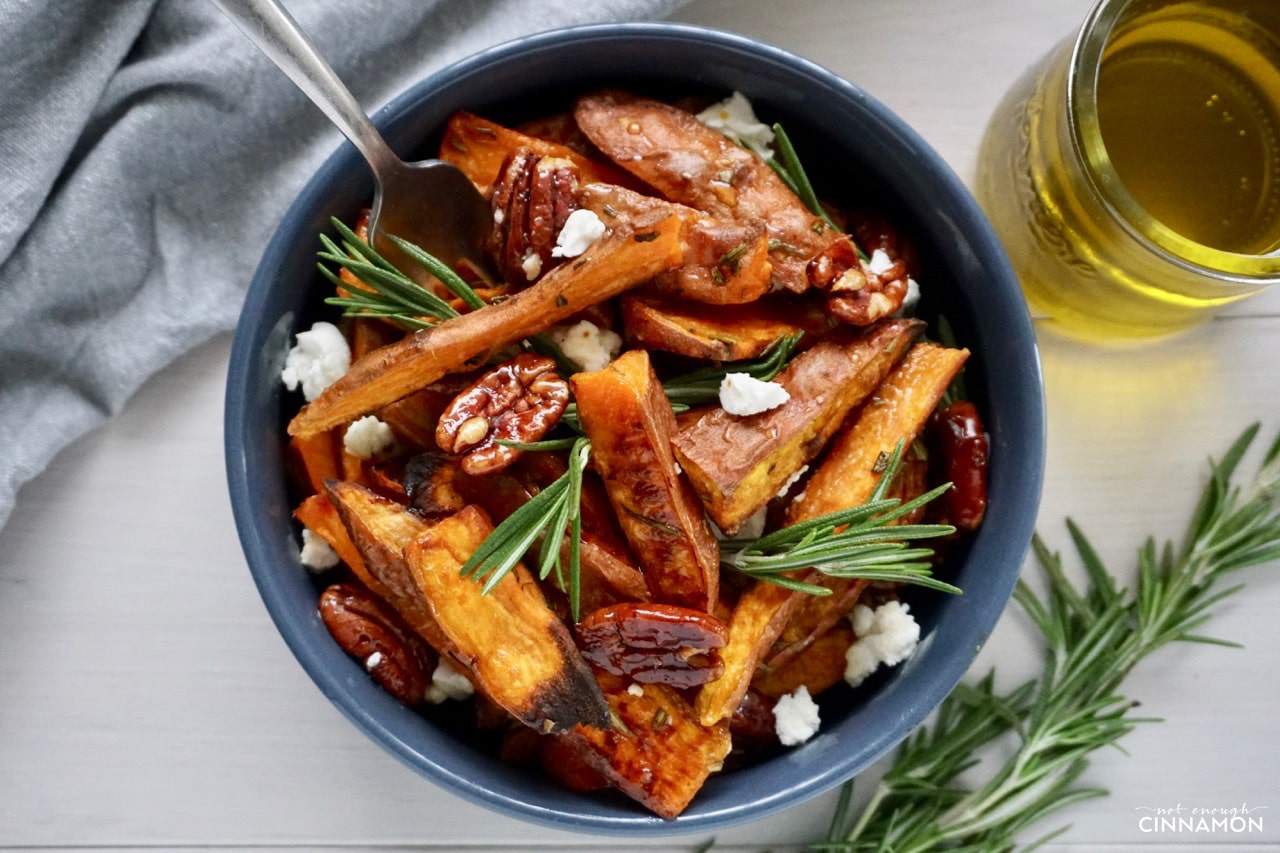 a small bowl with Sweet potato wedges, crumbled goat cheese, rosemary and candied pecans 