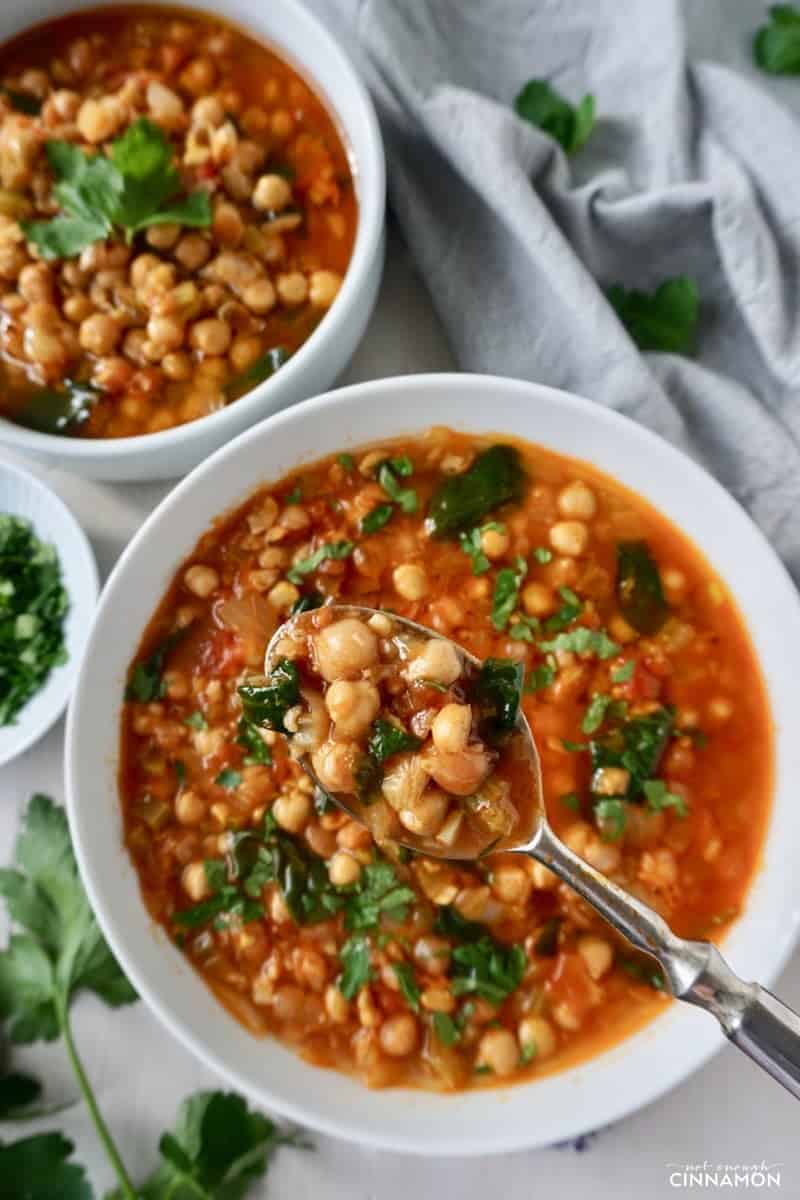 overhead shot of two bowls of Moroccan chickpea soup with cumin, paprika and cinnamon