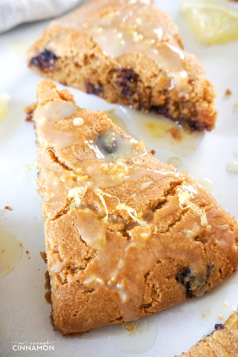 close-up of a lemon blueberry scone made with almond flour and drizzled with lemon glaze